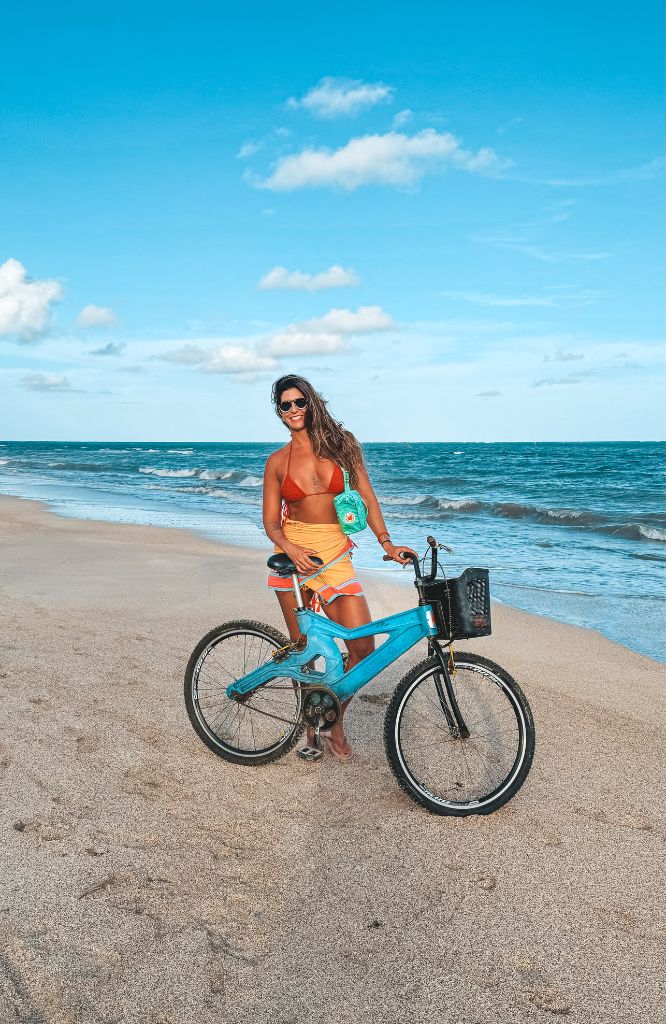 mulher de bike em praia