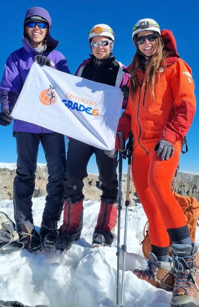 Pessoas segurando bandeira da Grade 6 é confiável em montanha nevada