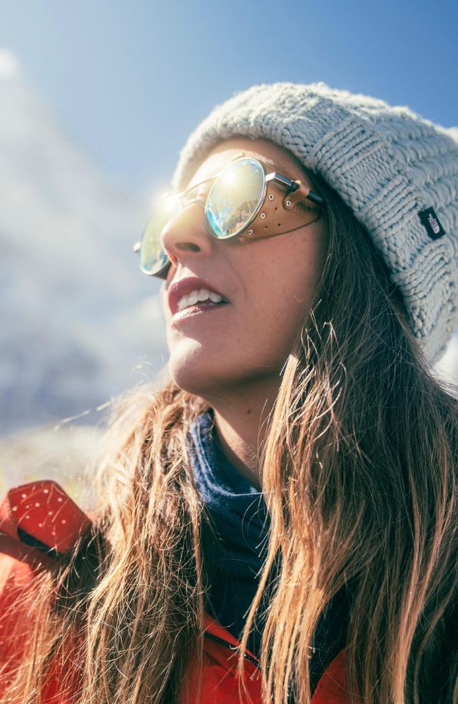 mulher de óculos e touca viajando com o melhor seguro viagem chile