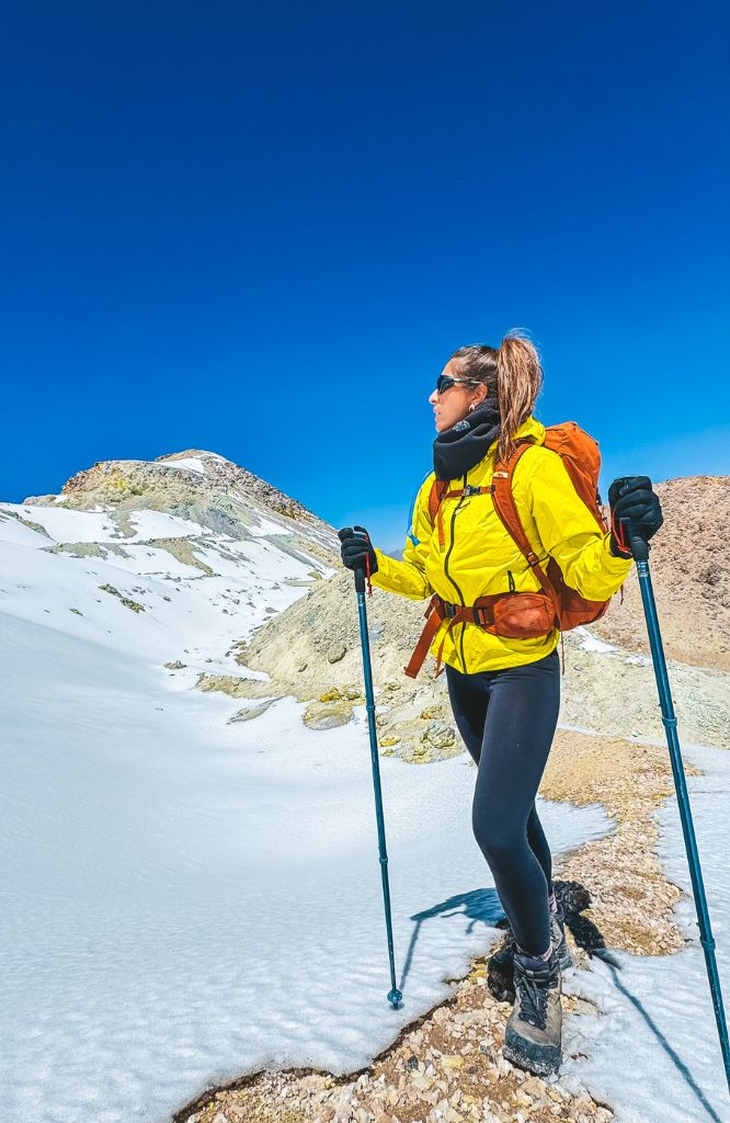 mulher caminhando na neve com roupa amarela
