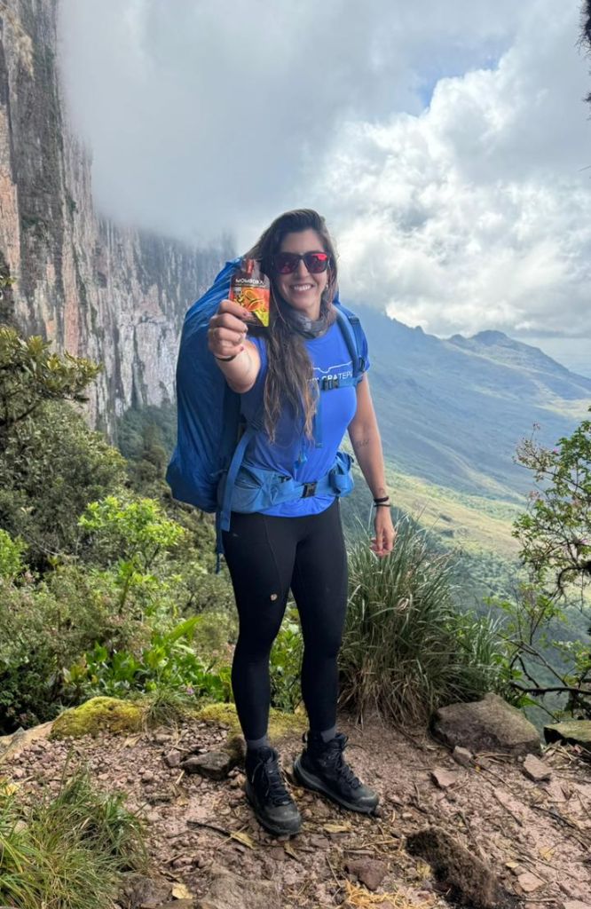 mulher de azul em trilha com melhor suplemento para treinar
